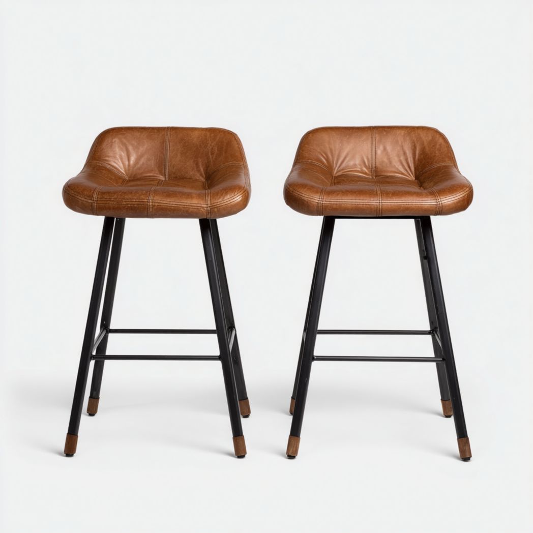 Juego de 2 taburetes de bar con asientos de piel sintética marrón y patas de metal negro.